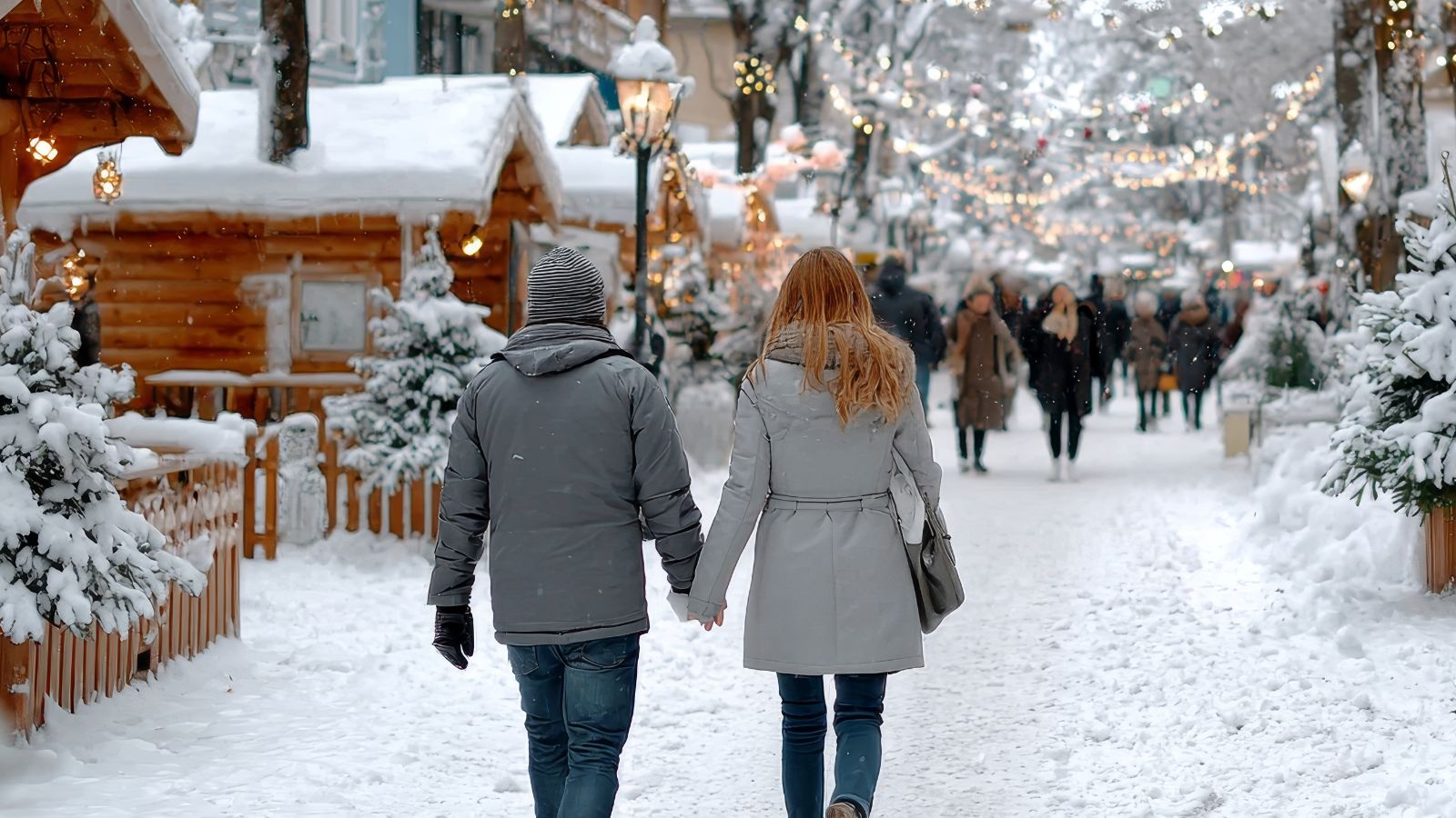 A photo of Couple bundled in winter coats walking slowly through a snowy Bavarian-style town street