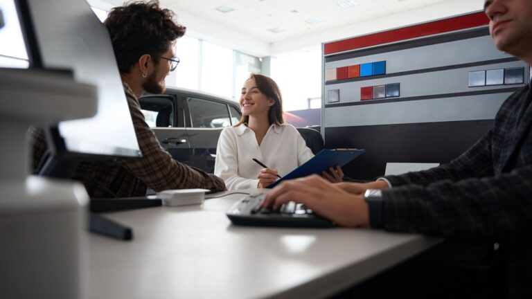 A photo of couple in a rental car counter looking happy.