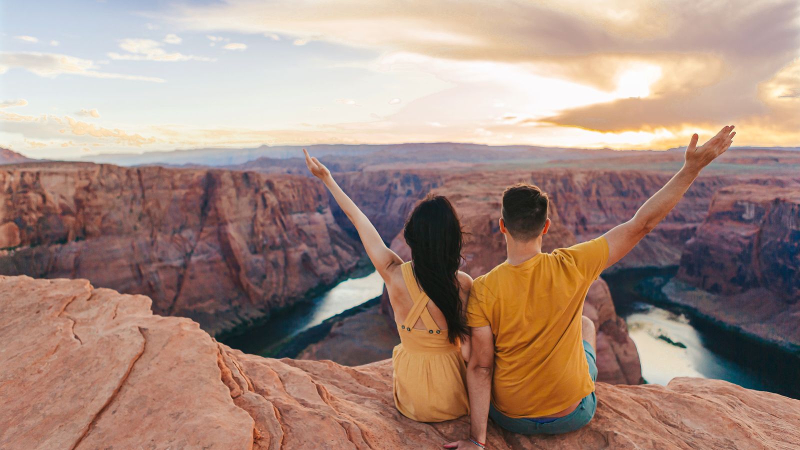 A photo of a Couple sitting on a private balcony facing Sedona’s glowing red rocks at sunset.
