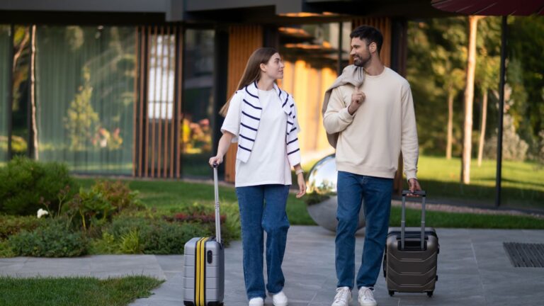 A photo of a couple, arriving at a resting place holding luggages.