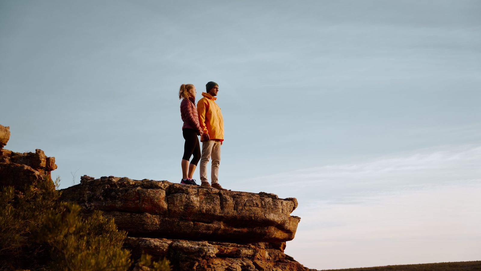 A photo of a couple showing warm golden light on sandstone formations, peaceful and intimate desert atmosphere.