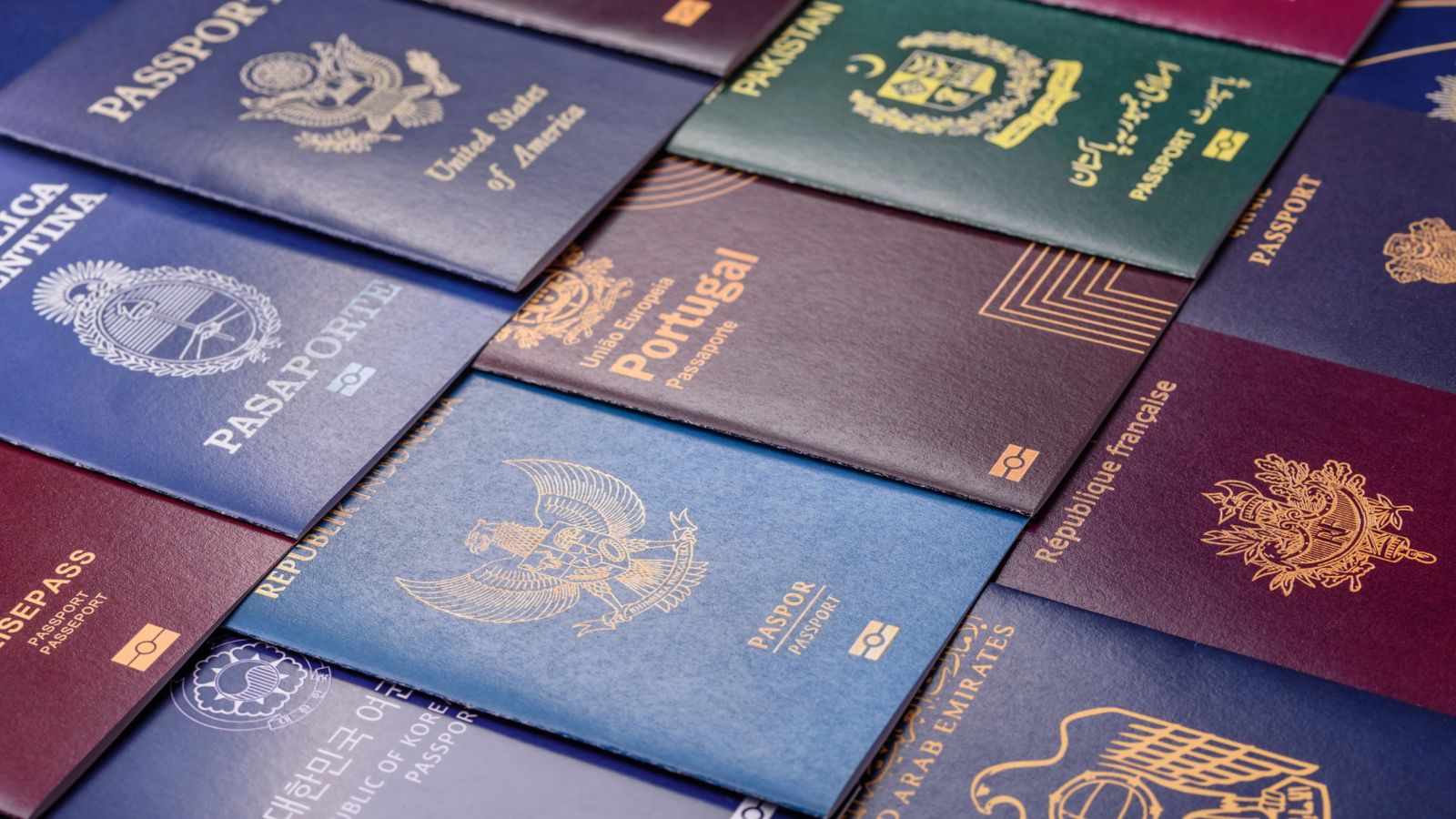 A photo of Close-up of multiple passports from different countries laid side by side.