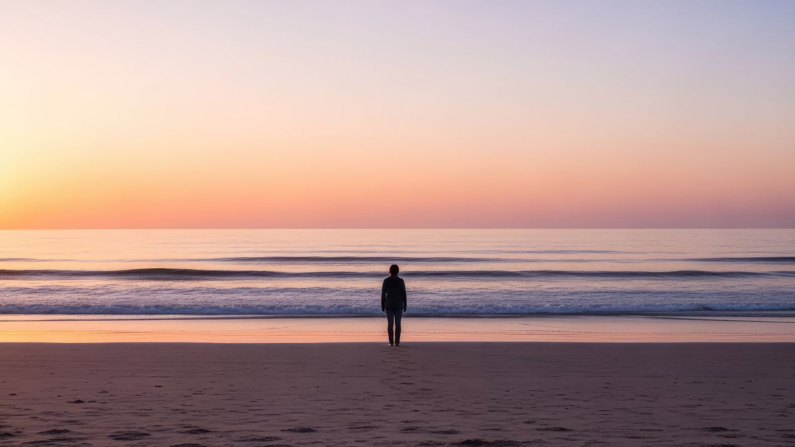 A photo of a Peaceful sunset over the ocean, waves rolling in steadily, traveler walking along shoreline with calm acceptance.