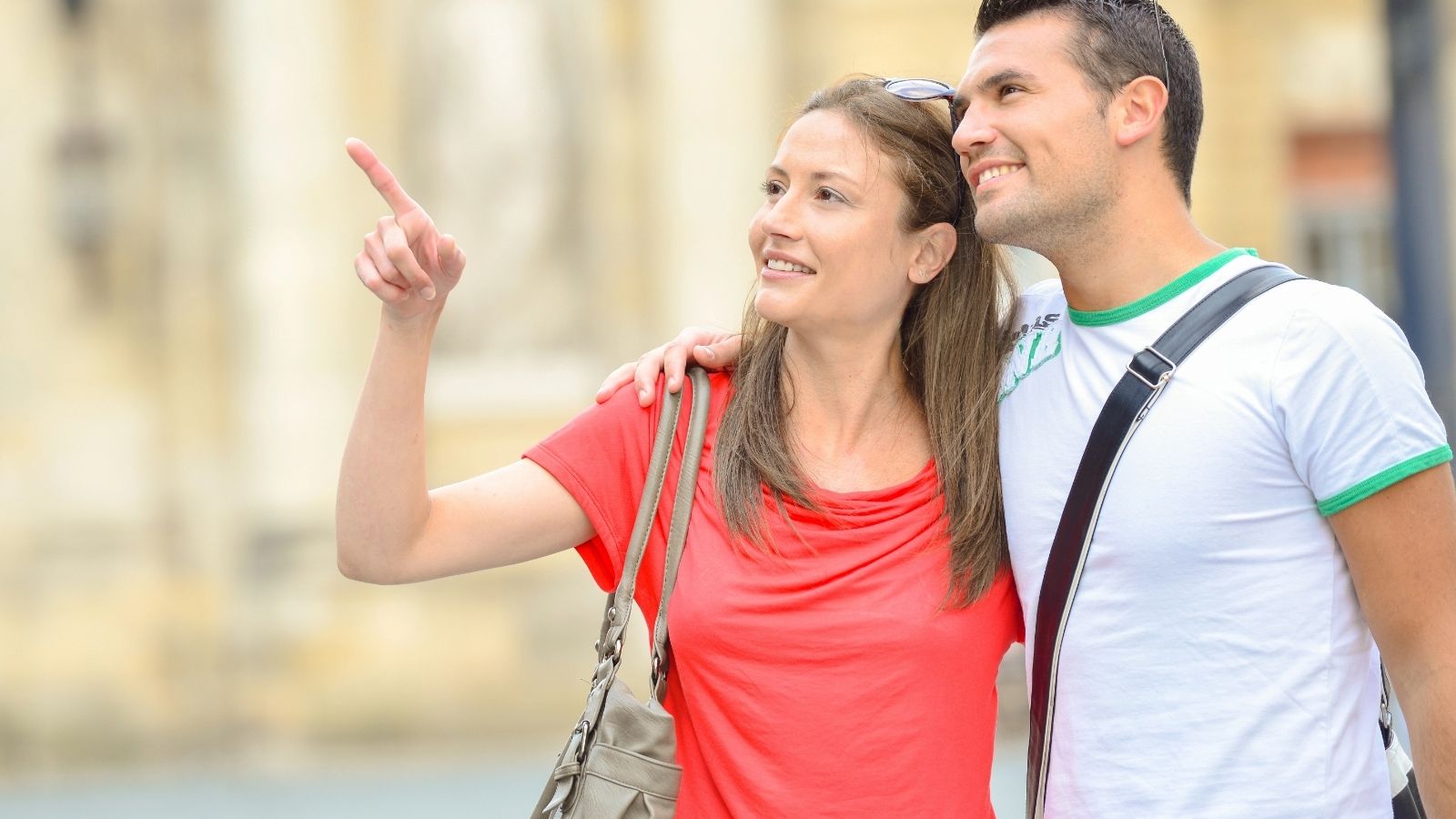 A couple sight-seeing, the woman is pointing at something.