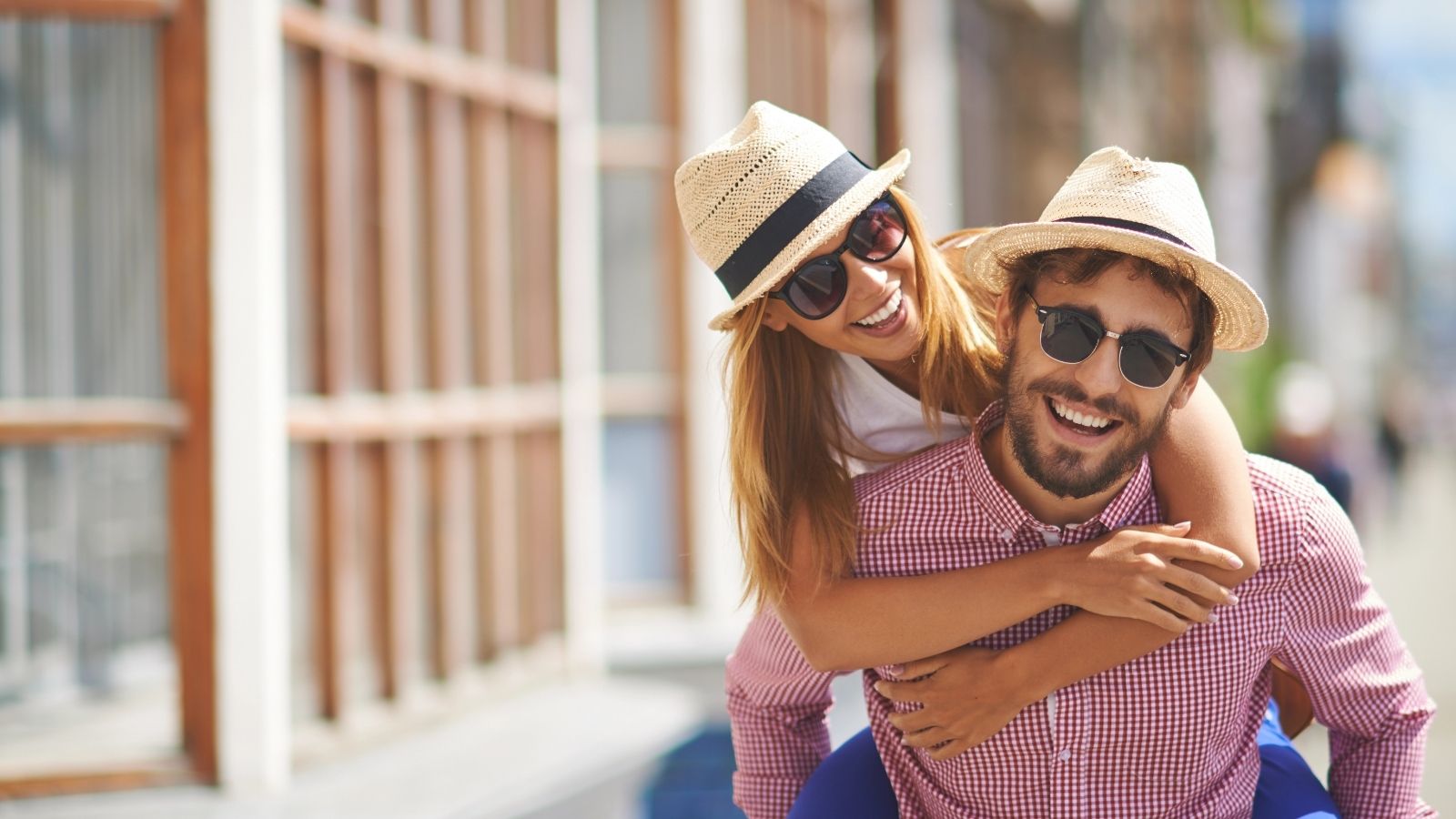 Happy couple in hats outdoors.