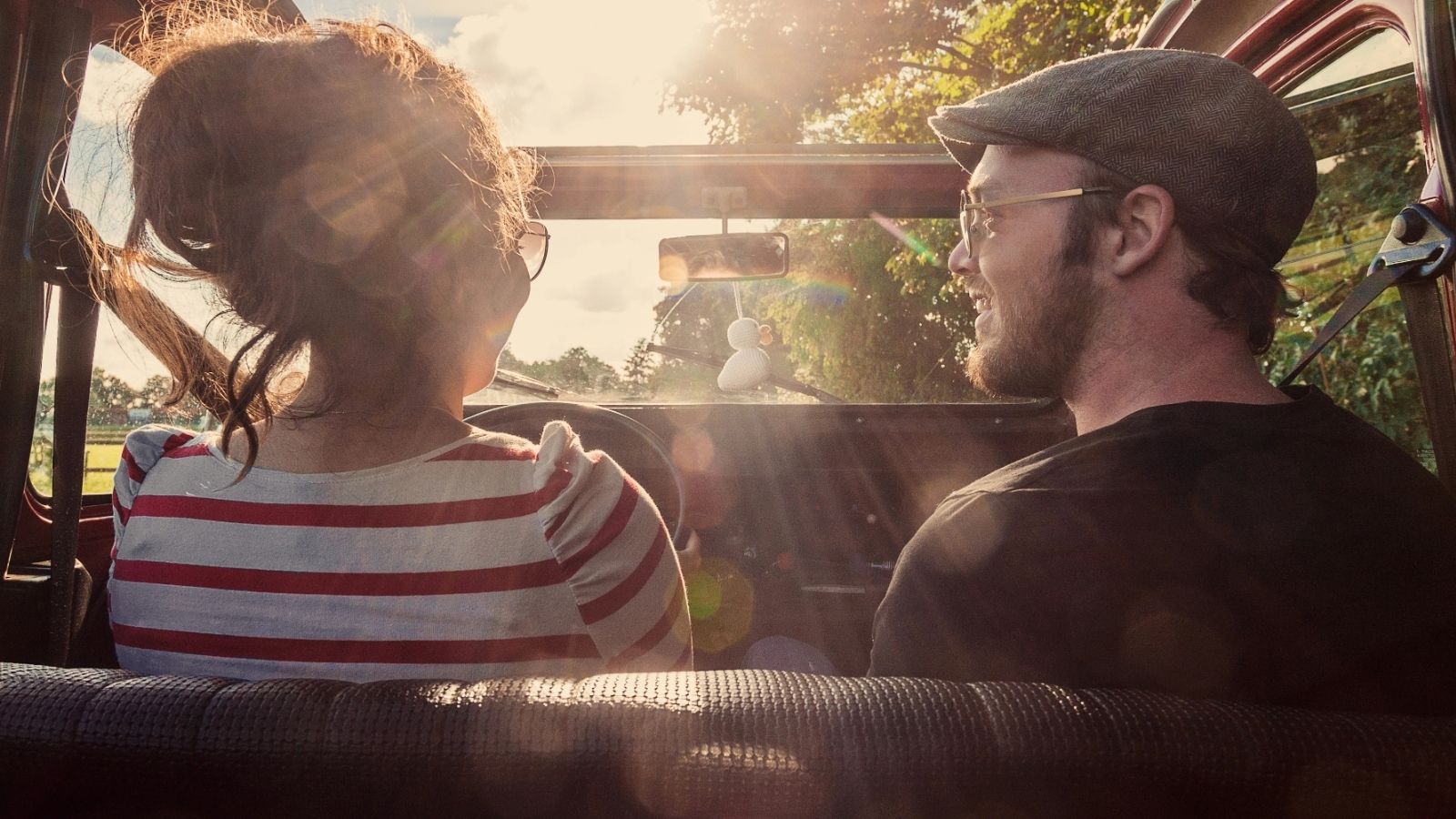 Young couple driving in an old convertible car.