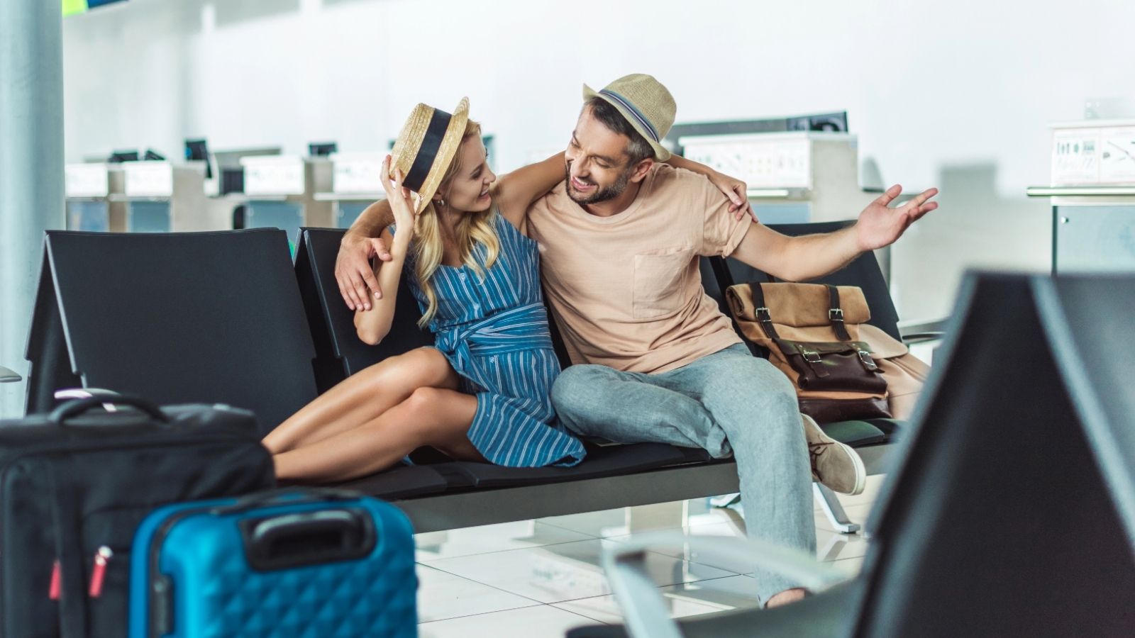 An image of a couple at the gate waiting area in the airport.