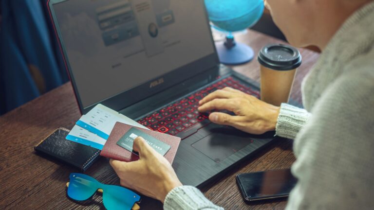 A photo of a man facing a laptop.