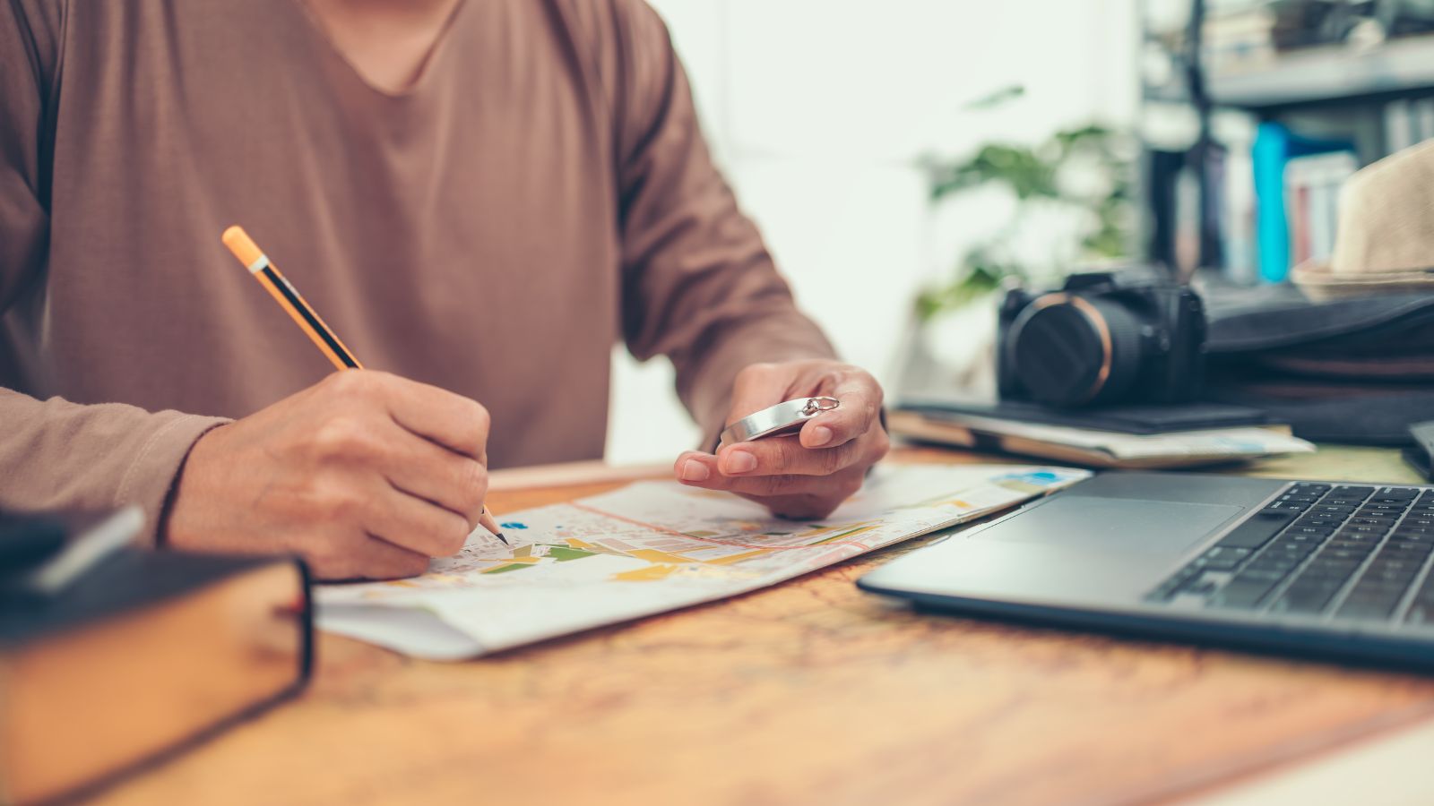 A photo of a man writing something in front of a map.