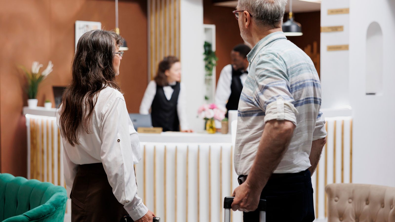 A photo of Mature traveler couple entering a well-designed hotel lobby.