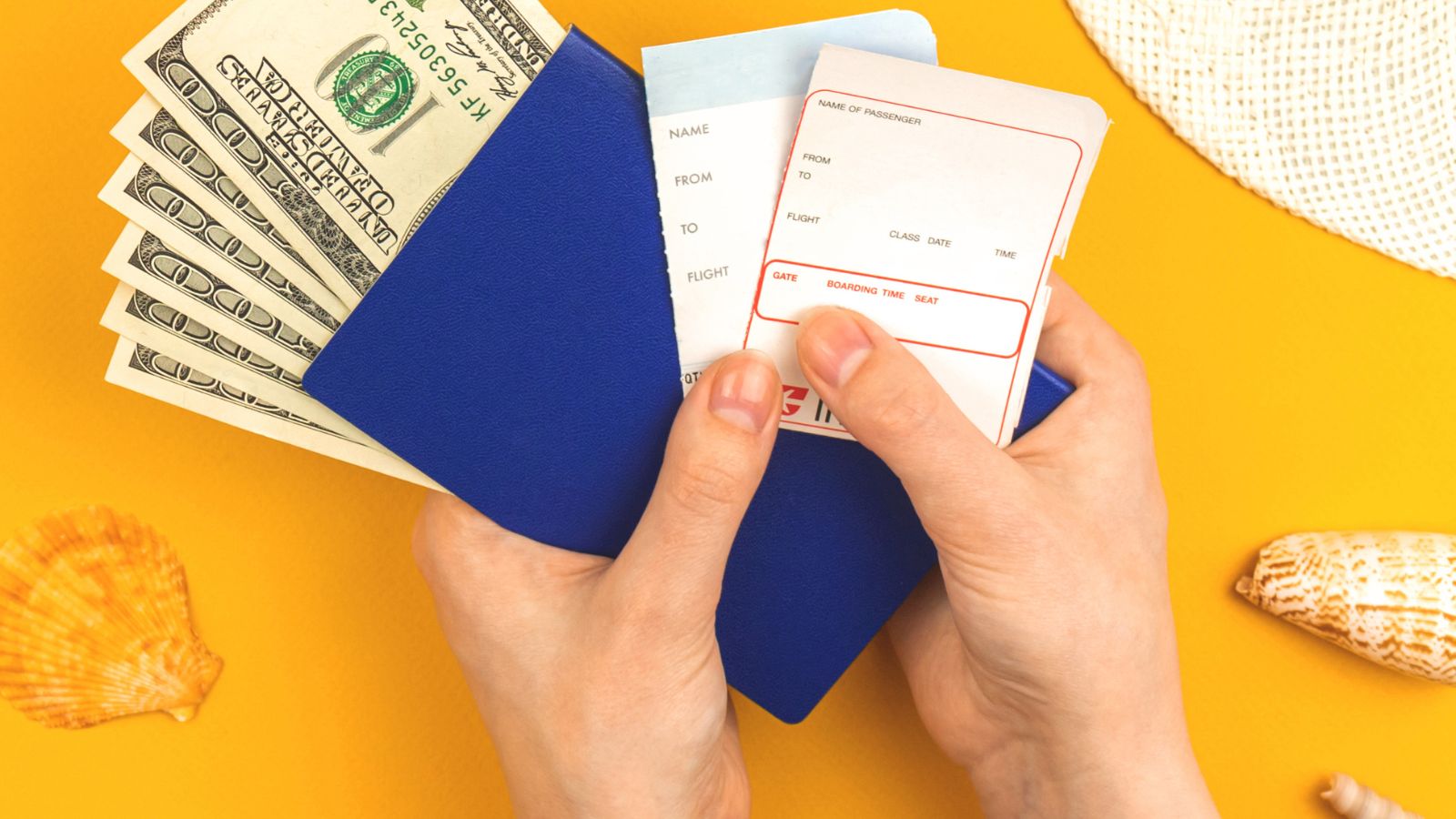 A photo of a hand holding both money and passport.
