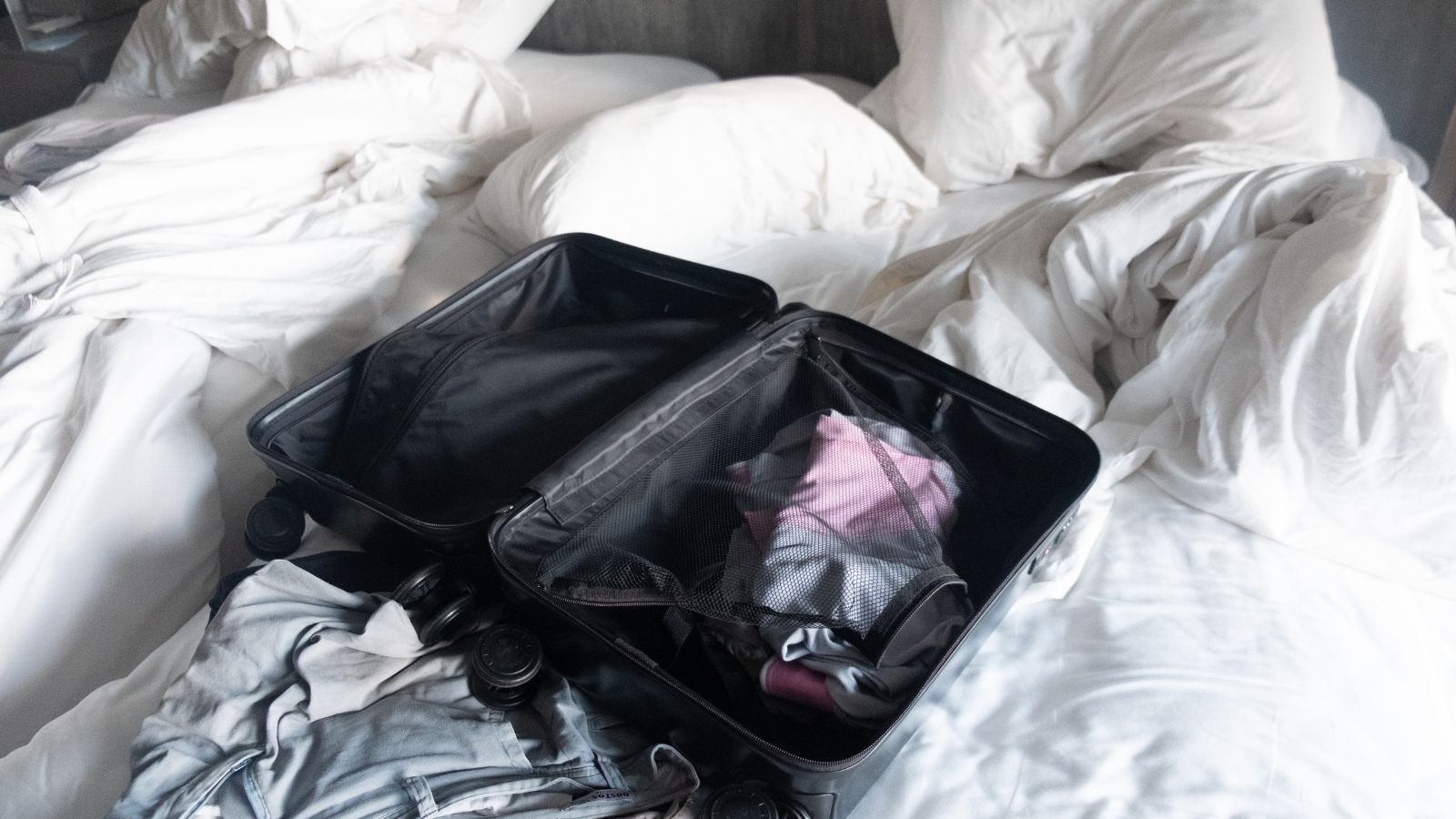 A photo of an Overpacked suitcase messy hotel.