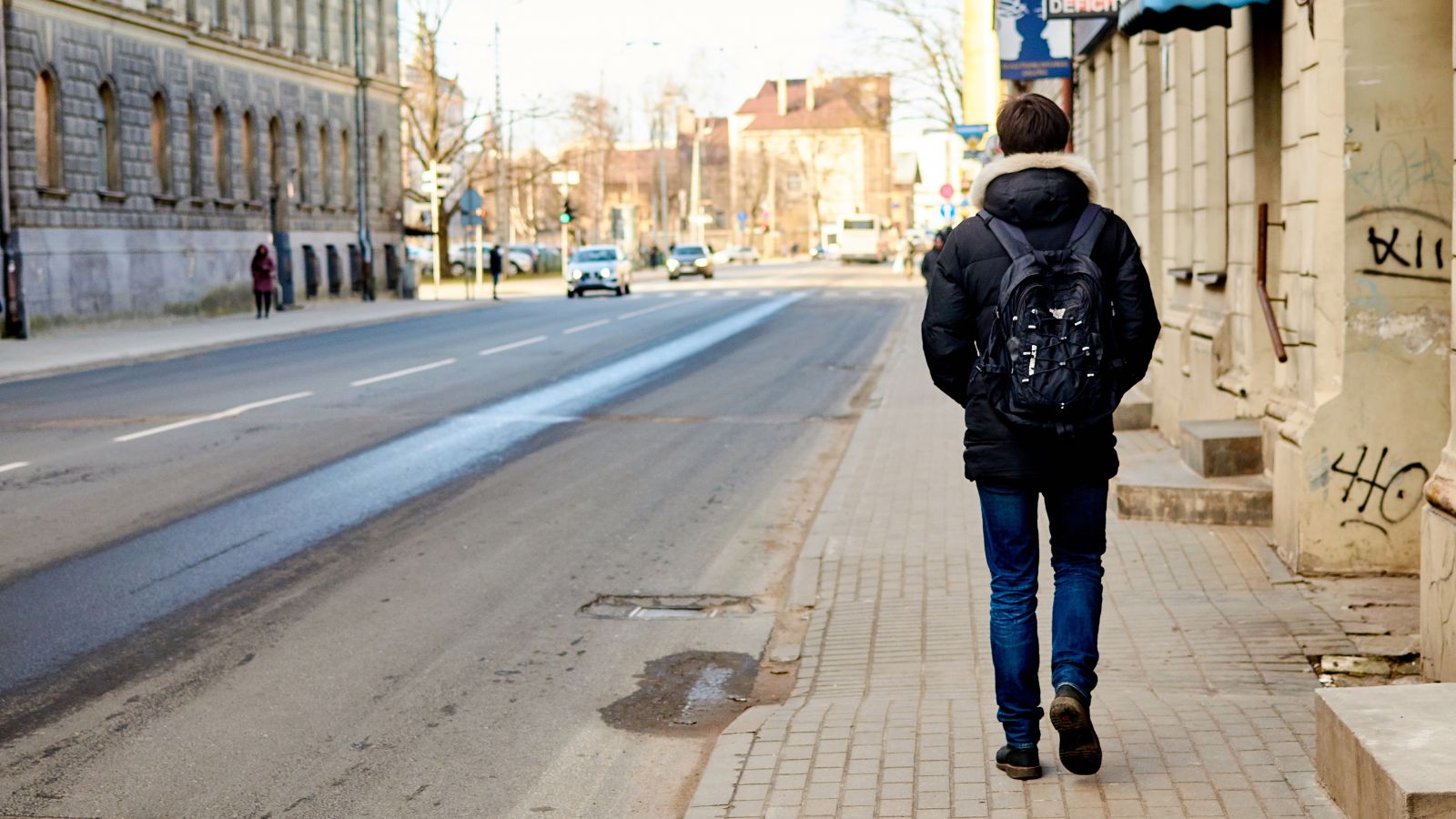A photo of a Traveler strolling empty city street morning.