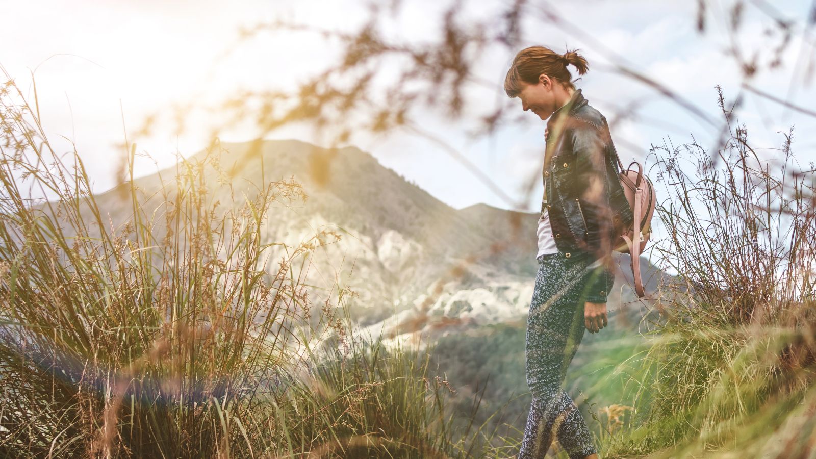 A photo of a raveler walking forward with calm confidence at a new scenic location.