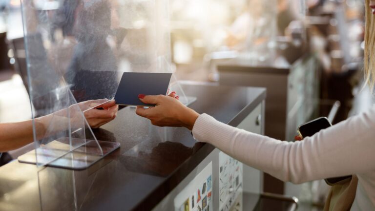 A photo of a hand of a woman handing her passport to an officer.