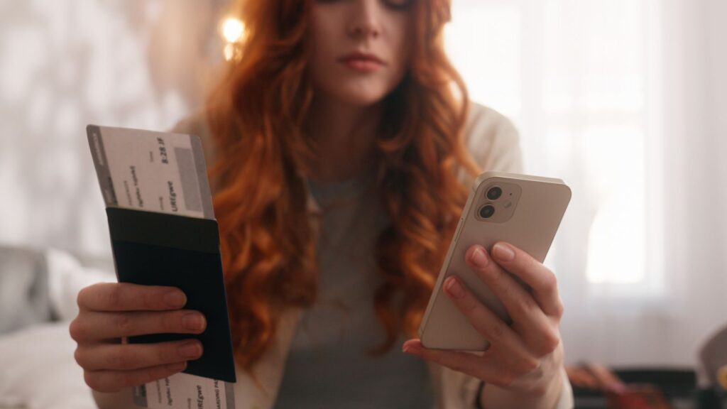 A photo of a woman holding both of her passport and phone.