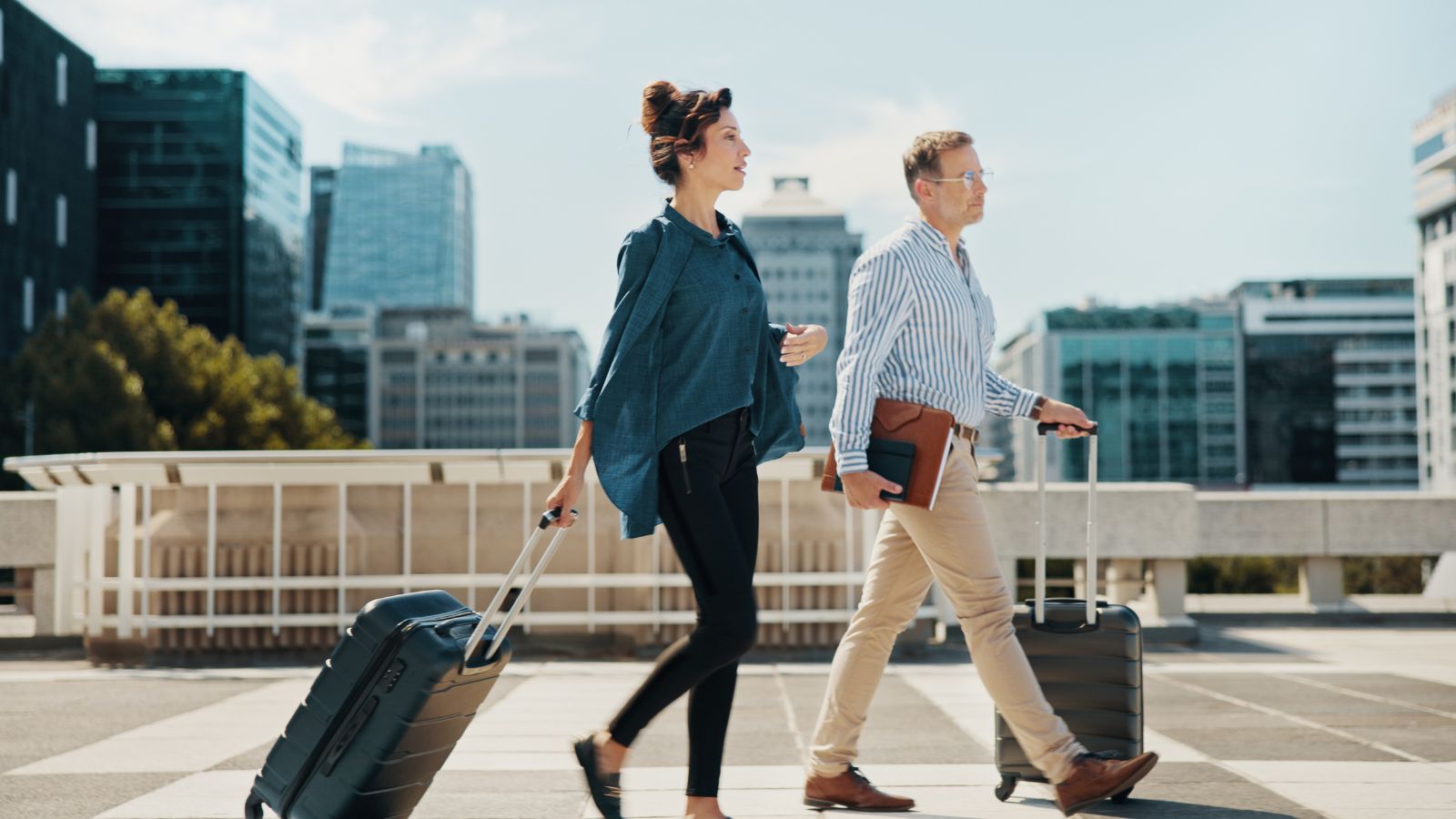 A photo of Young couple on their first trip together, walking side by side in an unfamiliar city, light luggage in hand, soft smiles, warm natural light, quiet excitement and sense of new beginnings.