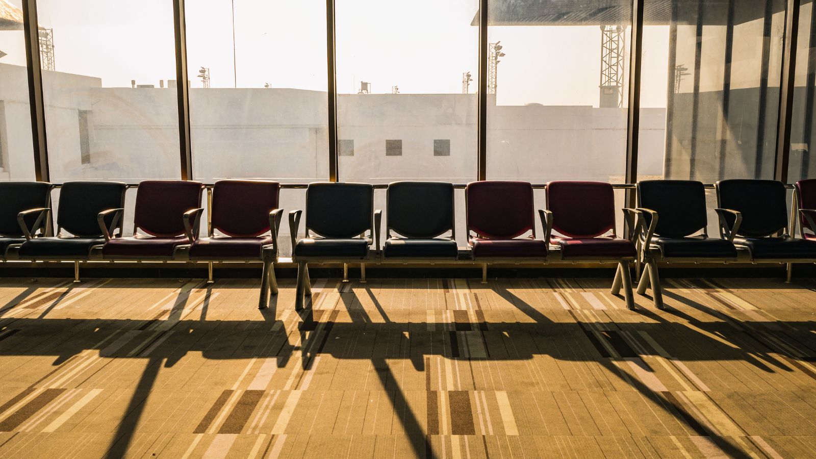 A photo of a quiet airport gate empty seating afternoon.