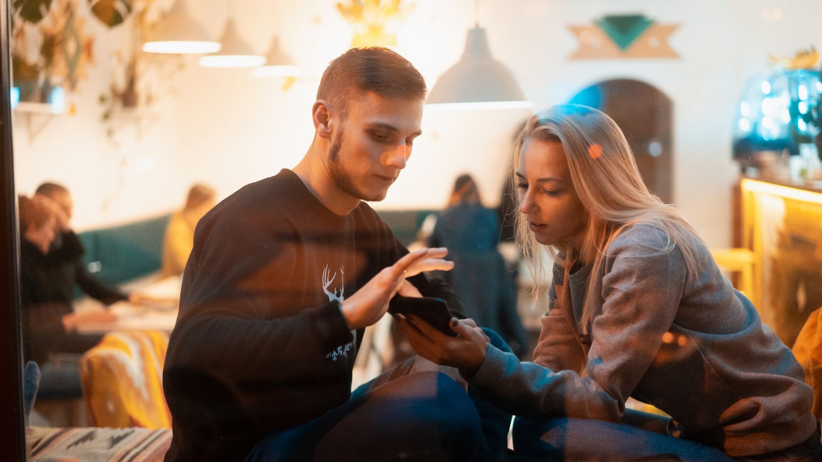 A man and woman look at a phone together.