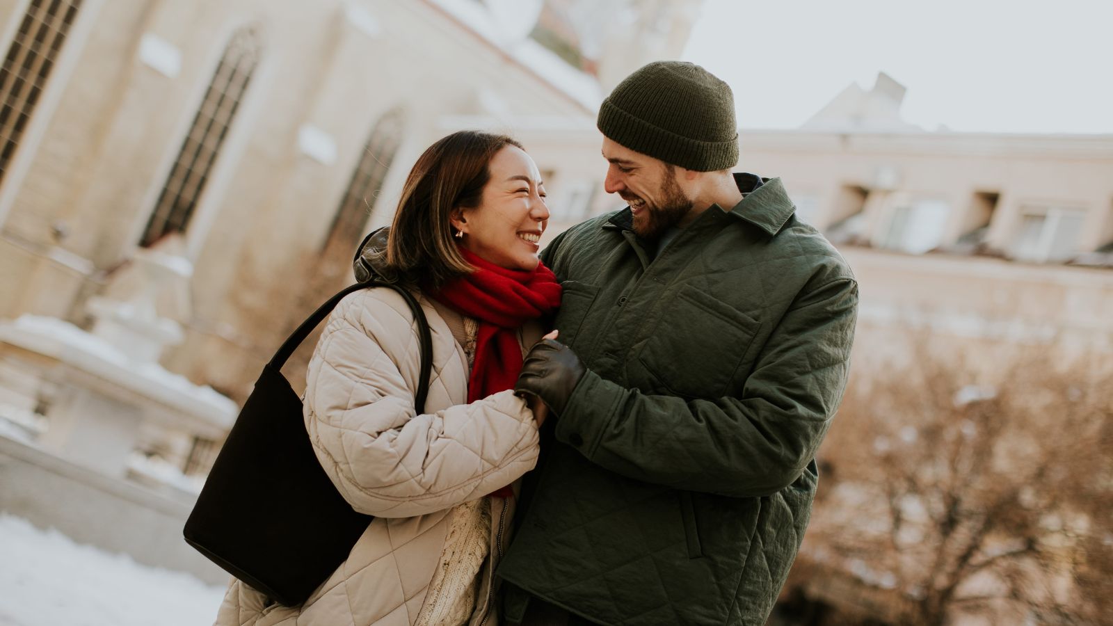 A photo of young couple looking happy smiling at each other.