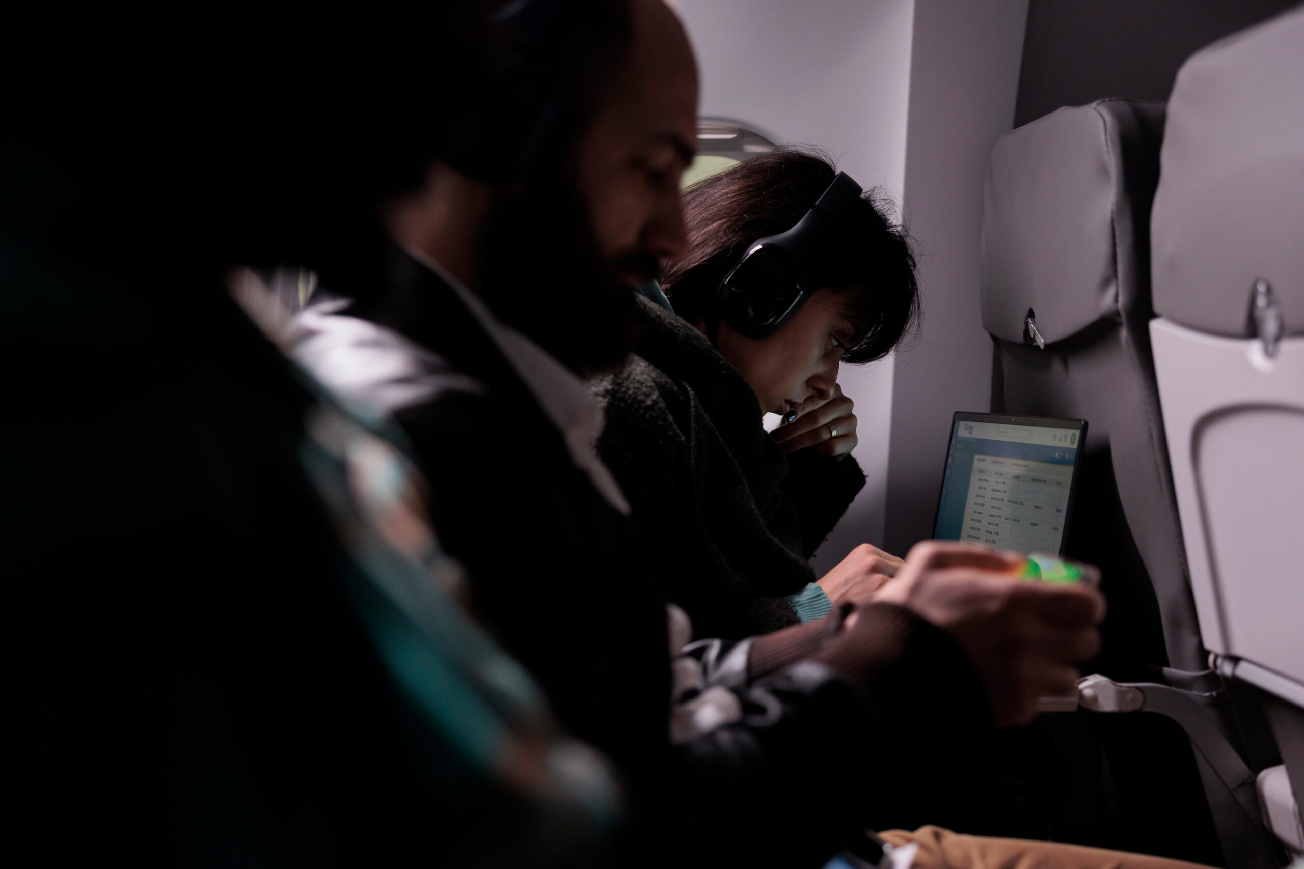 A photo of a Traveler on a long-haul flight looking tired in a standard economy seat.
