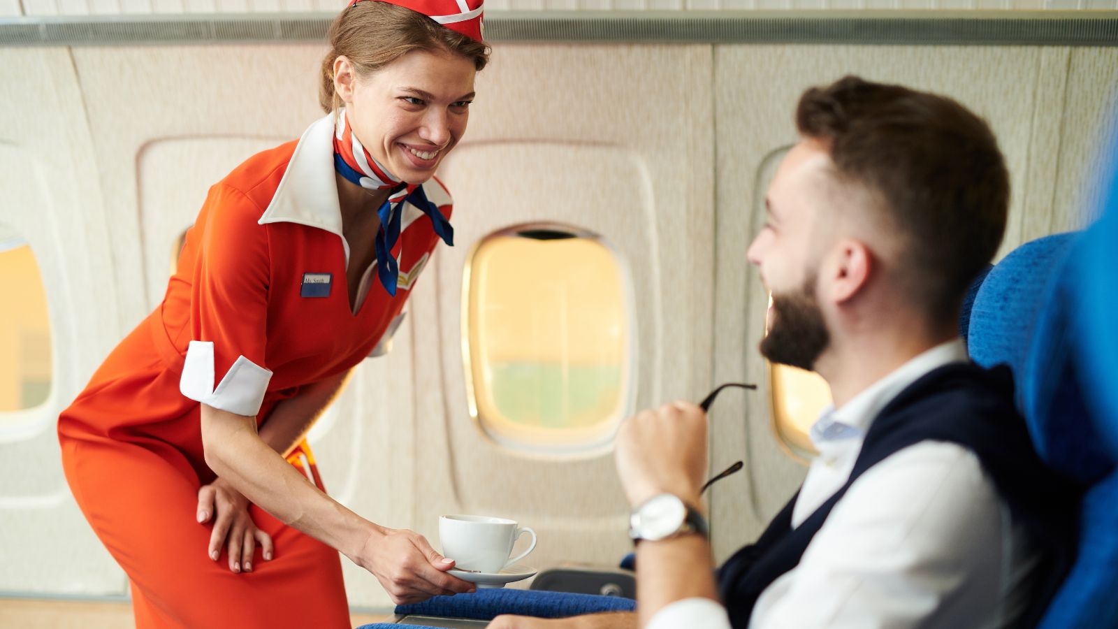 A photo of a flight attendant approaching a passenger.