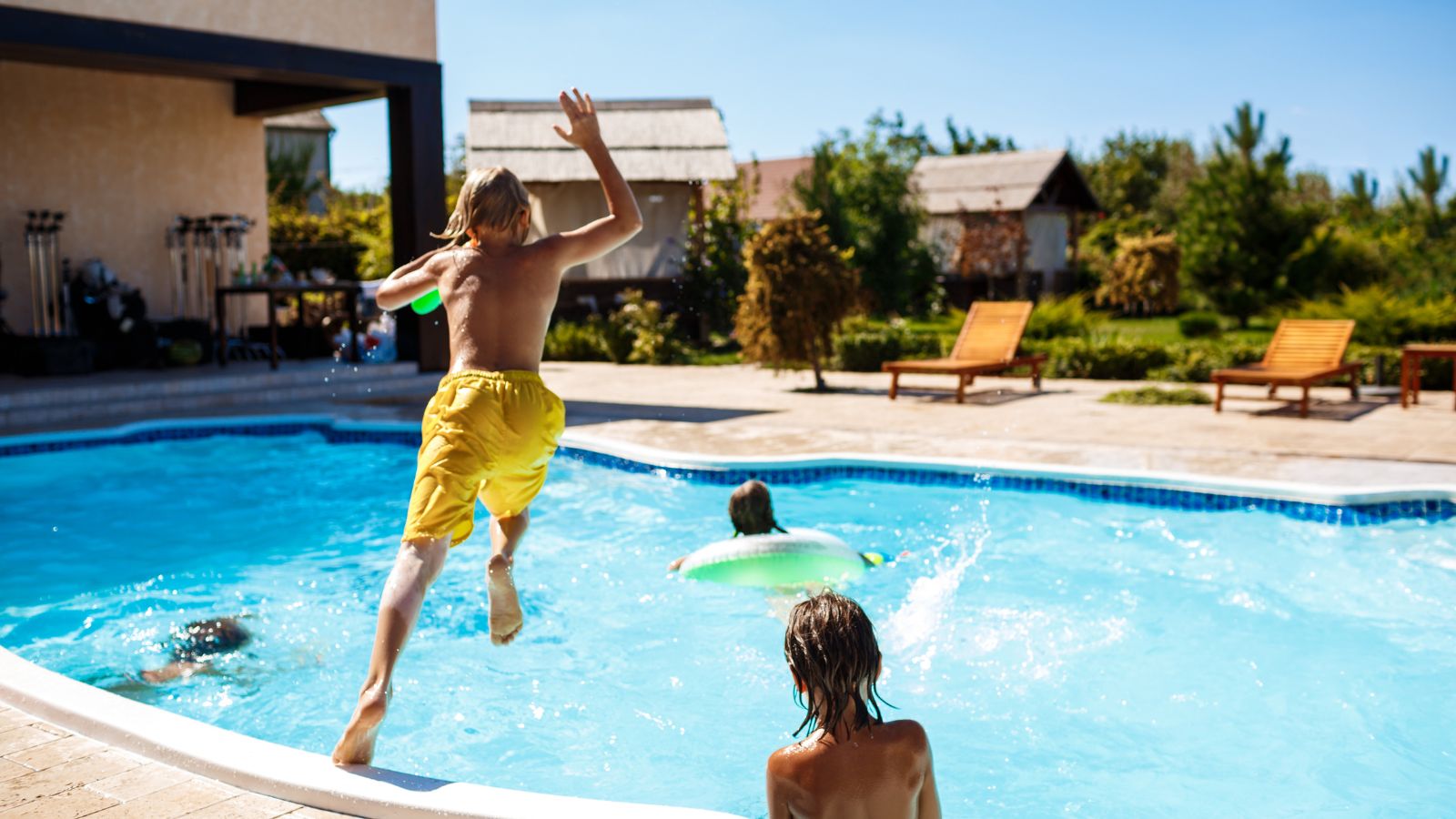 A photo of poolside hotel view, daytime activity, children playing, towels flapping, lively but realistic scene.