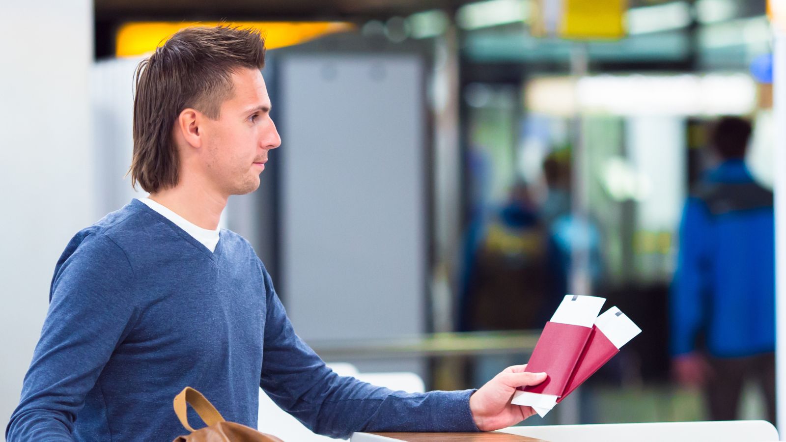 A photo of traveler holding passport airport security line.