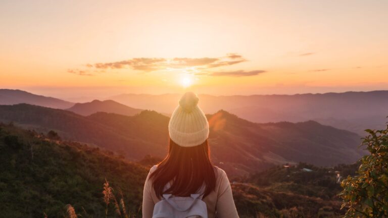 A photo of a peaceful traveler at a quiet sunrise.