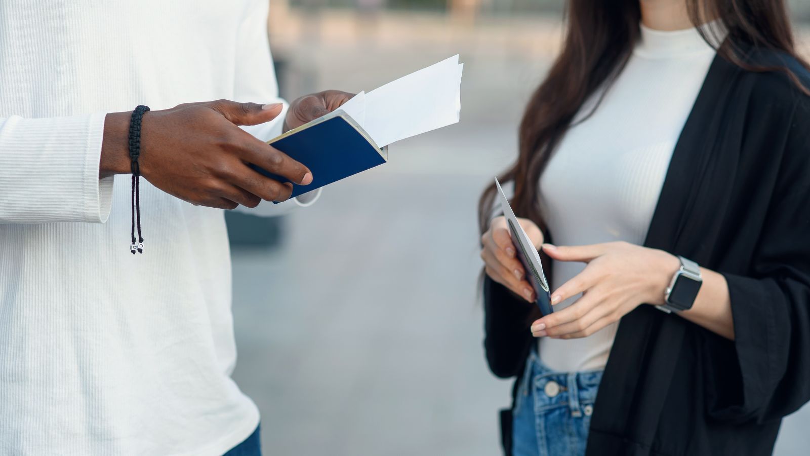 A photo of travelers with passports each hand.