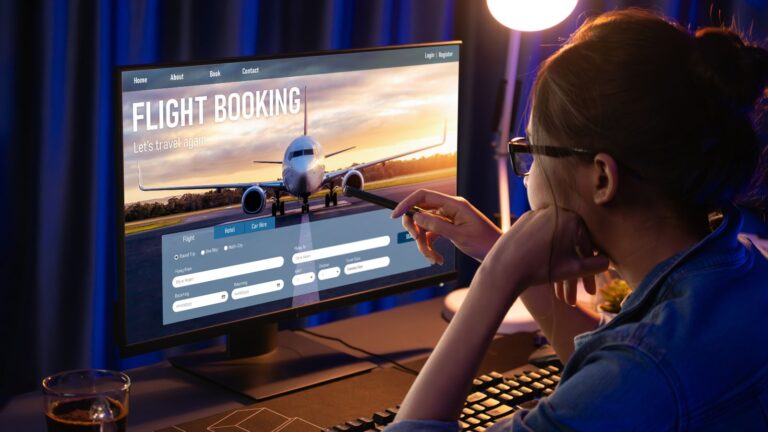 A photo of a Traveler booking an international flight on a laptop late at night.