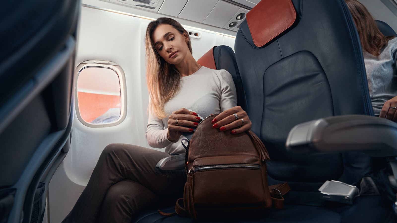 A photo that shows passenger storing bag under airplane seat properly.