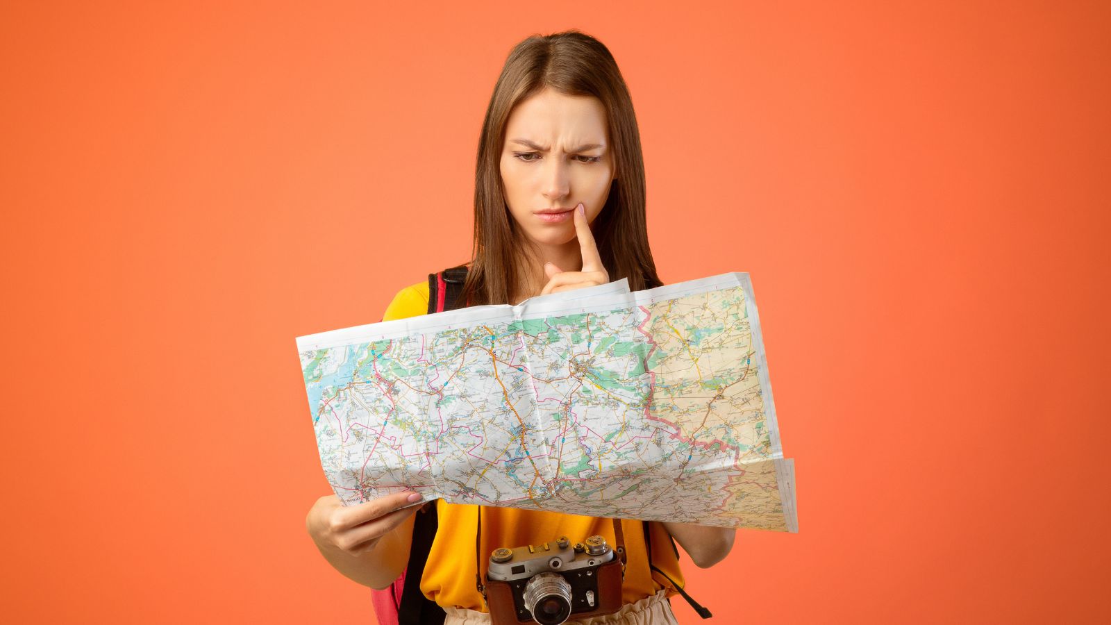A photo of a woman looking like she is thinking deeply while facing a map.