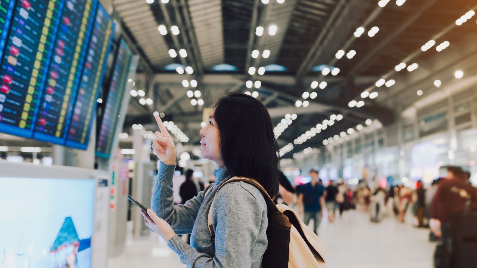 A photo that shows woman looking at boarding screen.
