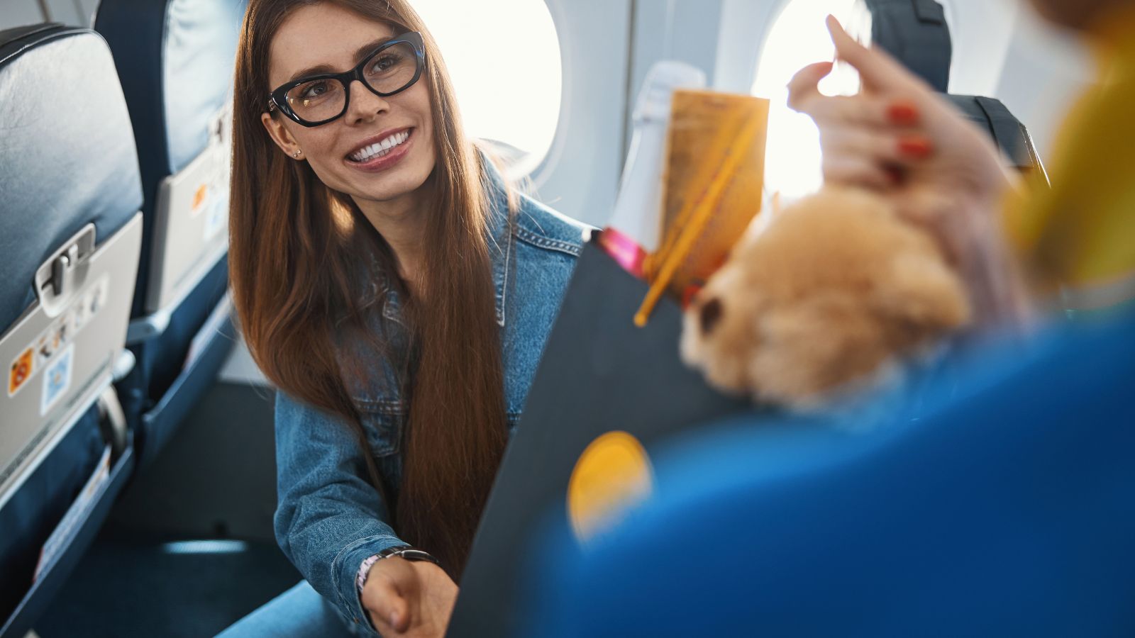 A photo of passenger greeting flight attendant with smile while boarding airplane.