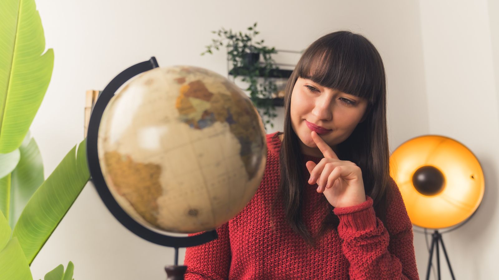 A photo of a woman thinking carefully while looking at the globe.