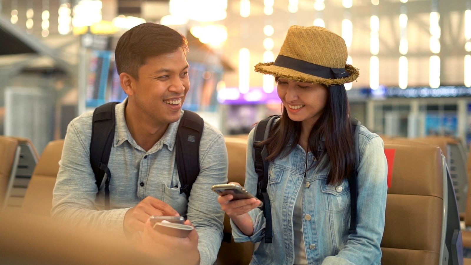 A photo of a couple with matching denim jacket ready for travel.