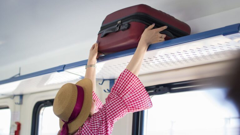 A photo of a woman putting luggage.