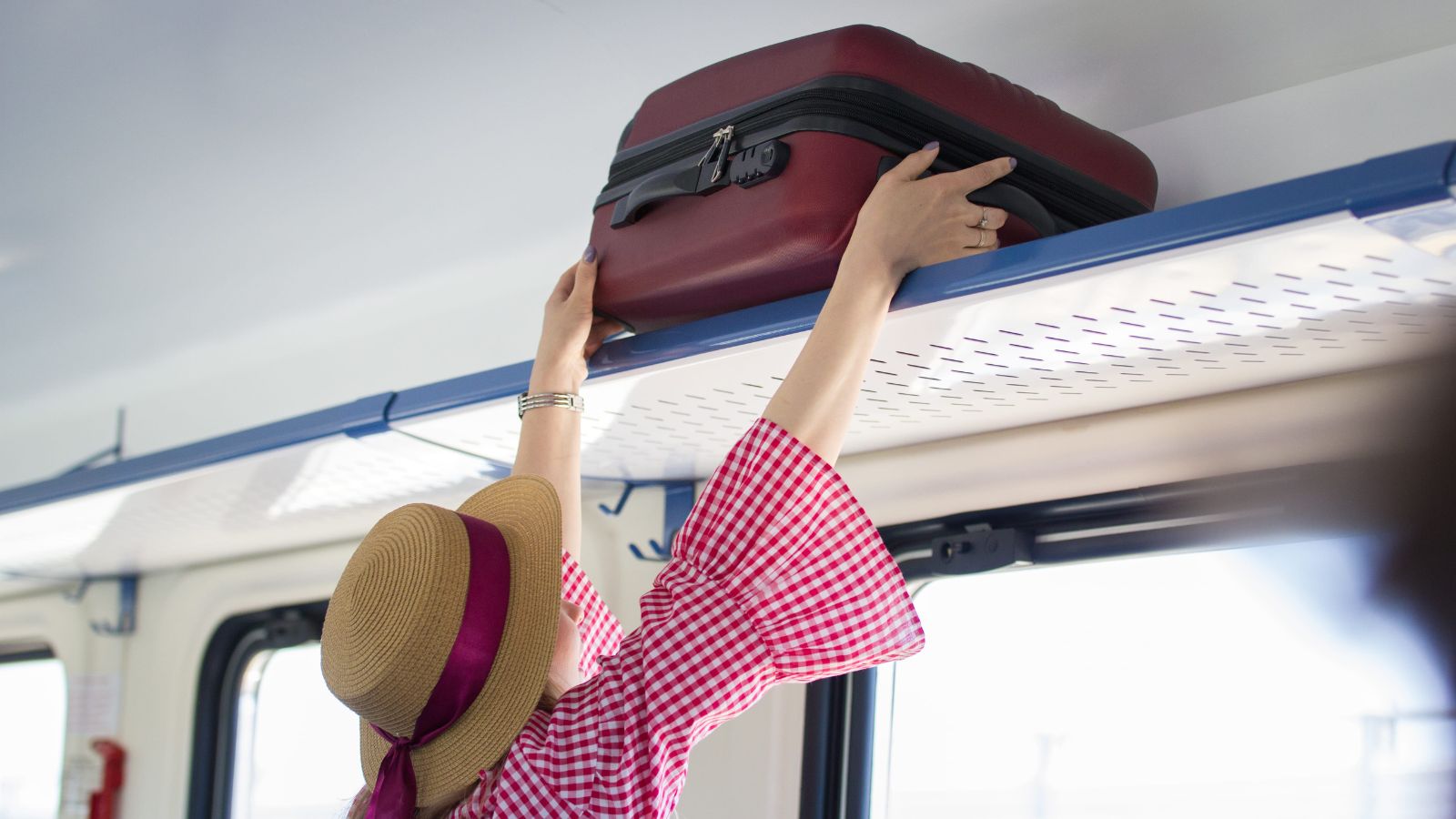 A photo of a woman putting luggage.