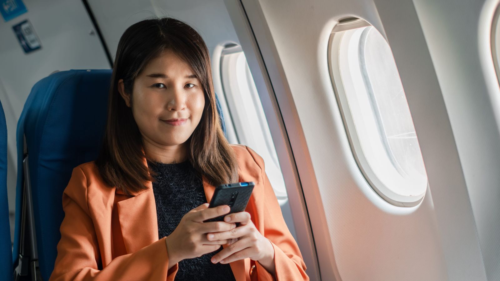 A photo of a passengers seated comfortably in airplane calm organized cabin relaxed travel experience natural light.