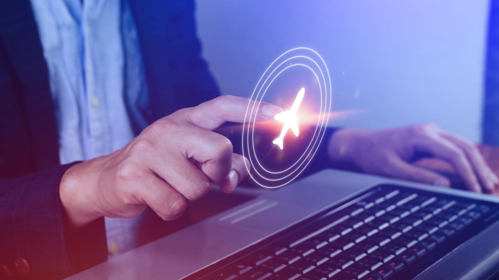 A person points to a digital airplane icon above a laptop keyboard, implying online flight booking.