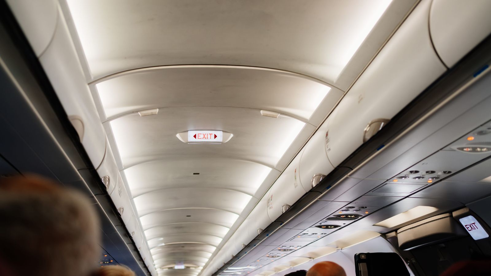 A photo of airplane cabin passengers sitting in aisle window and middle seats showing comfort differences long flight travel realistic.