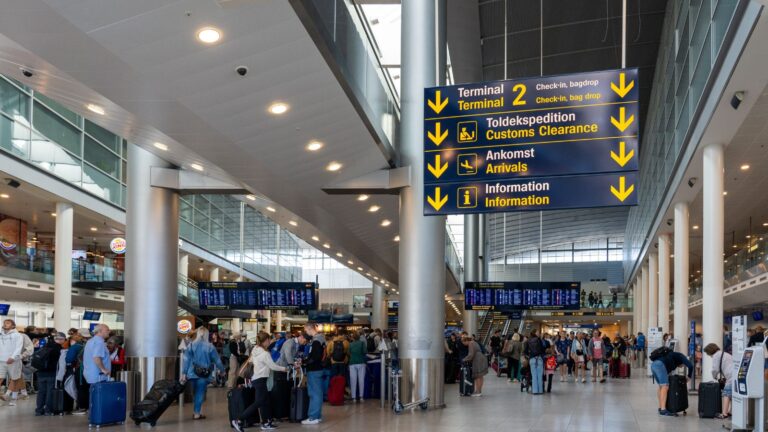 A photo of a peaceful early morning airport terminal with a few relaxed travelers boarding a flight, showing a smooth start to a trip.
