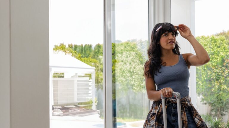 A photo of a woman entering hotel with observant look.