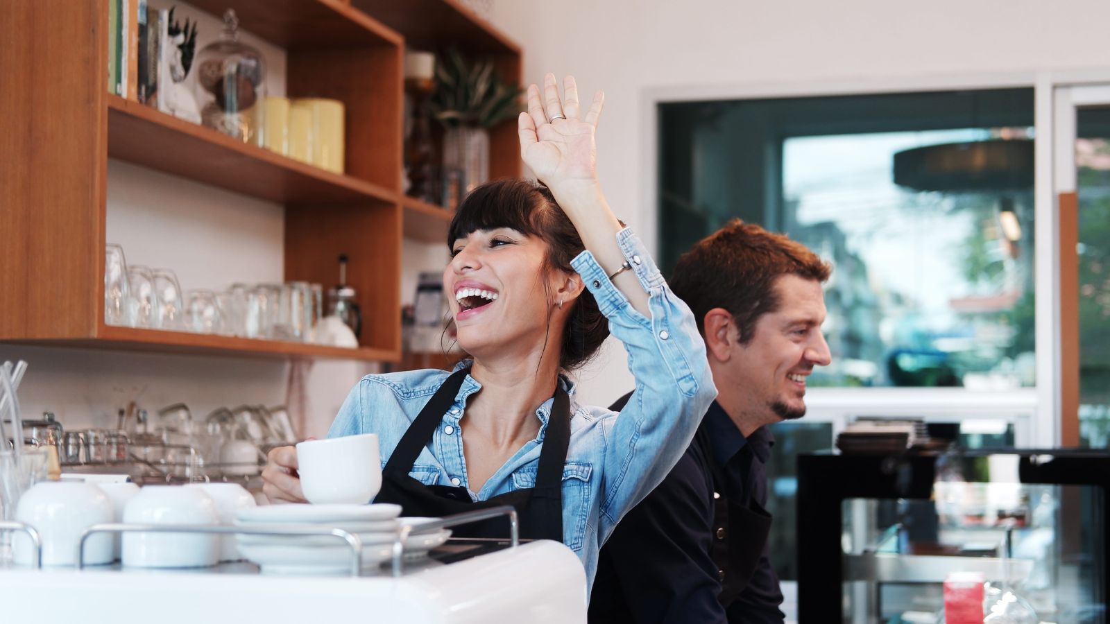 A photo of traveler smiling and saying goodbye to a shopkeeper in a small European bakery