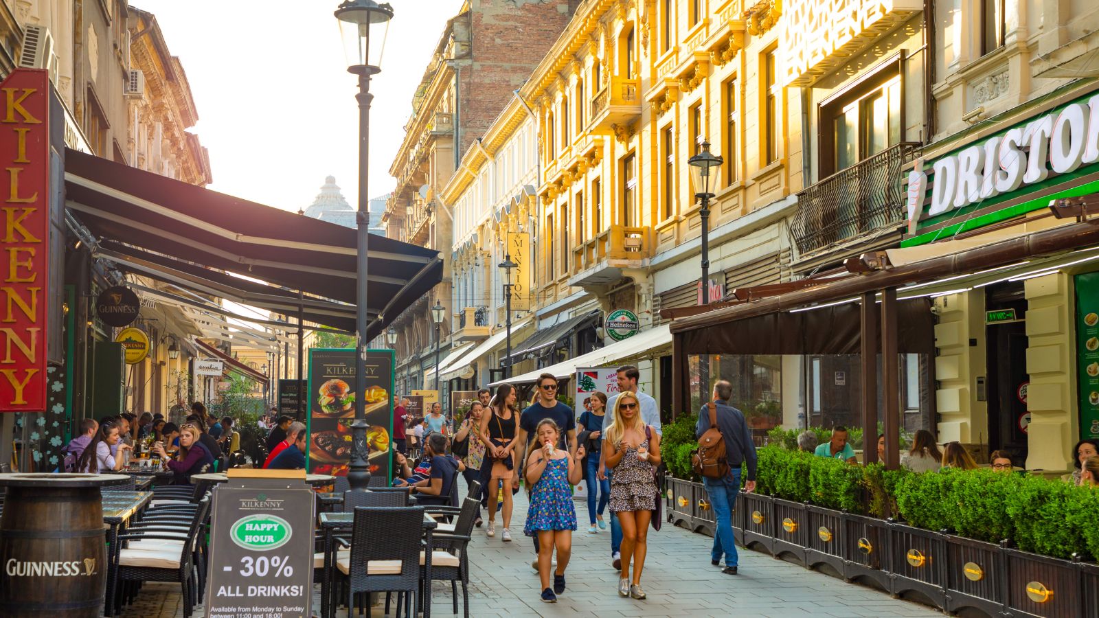 A photo of a busy outdoor café terrace in a European city with people eating and watching the street