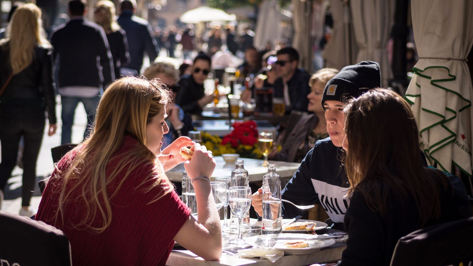 A photo that shows people dining at outdoor european cafe relaxed atmosphere not rushed enjoying meal slow dining culture barcelona or florence candid natural light.