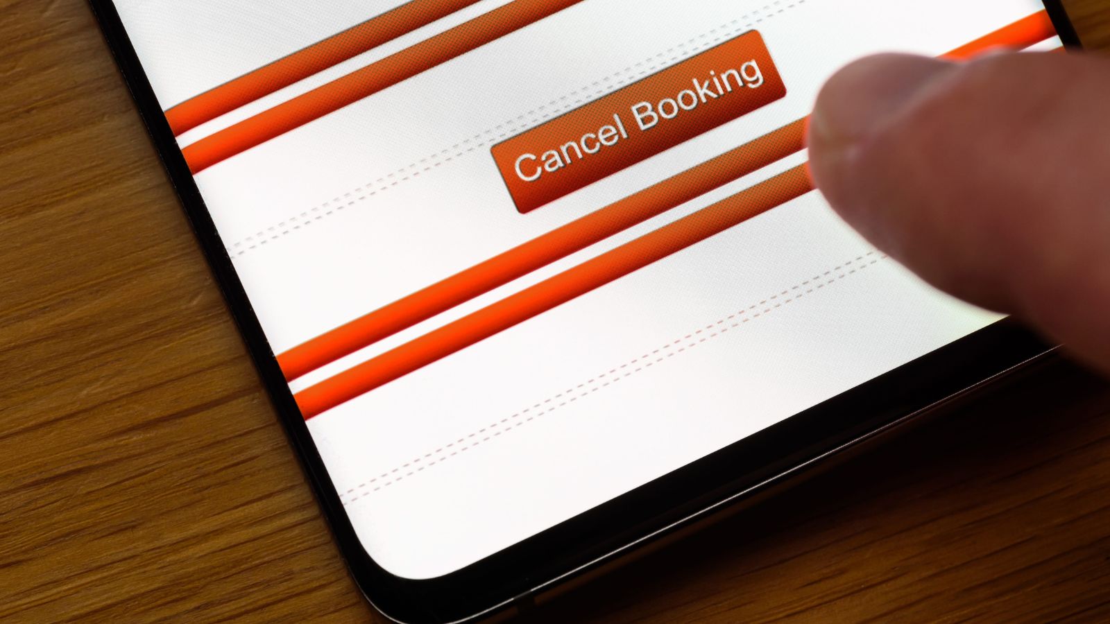 A finger hovers over the "Cancel Booking" button on a smartphone's online booking interface.