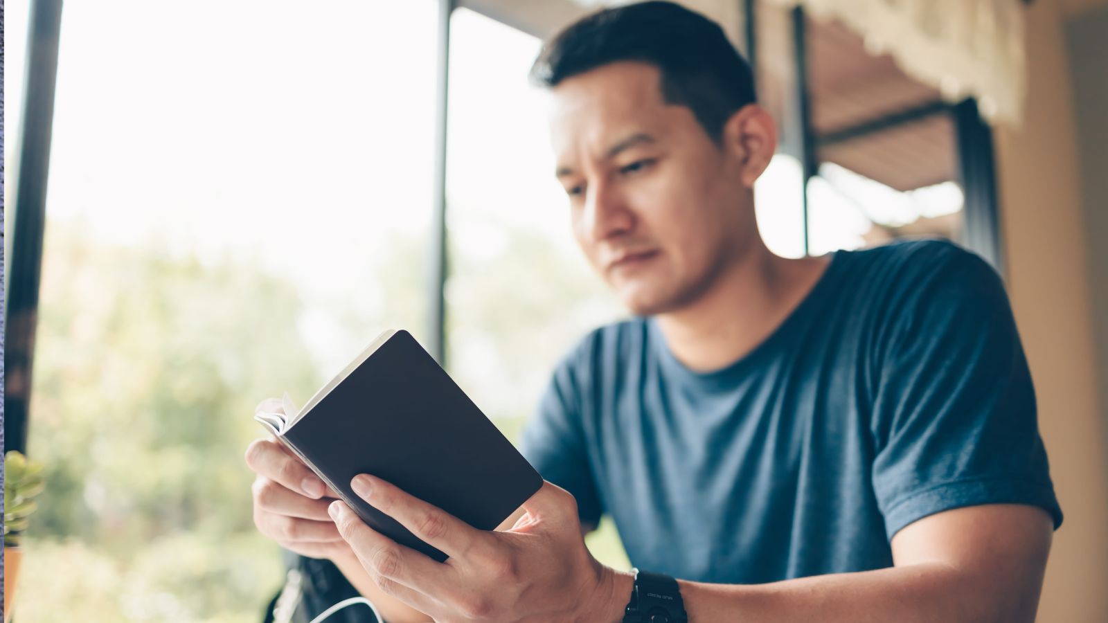 A photo of a Traveler thoughtfully considering holiday options, calm and reflective, notebook or tablet in hand, soft colors, conveys planning before booking.