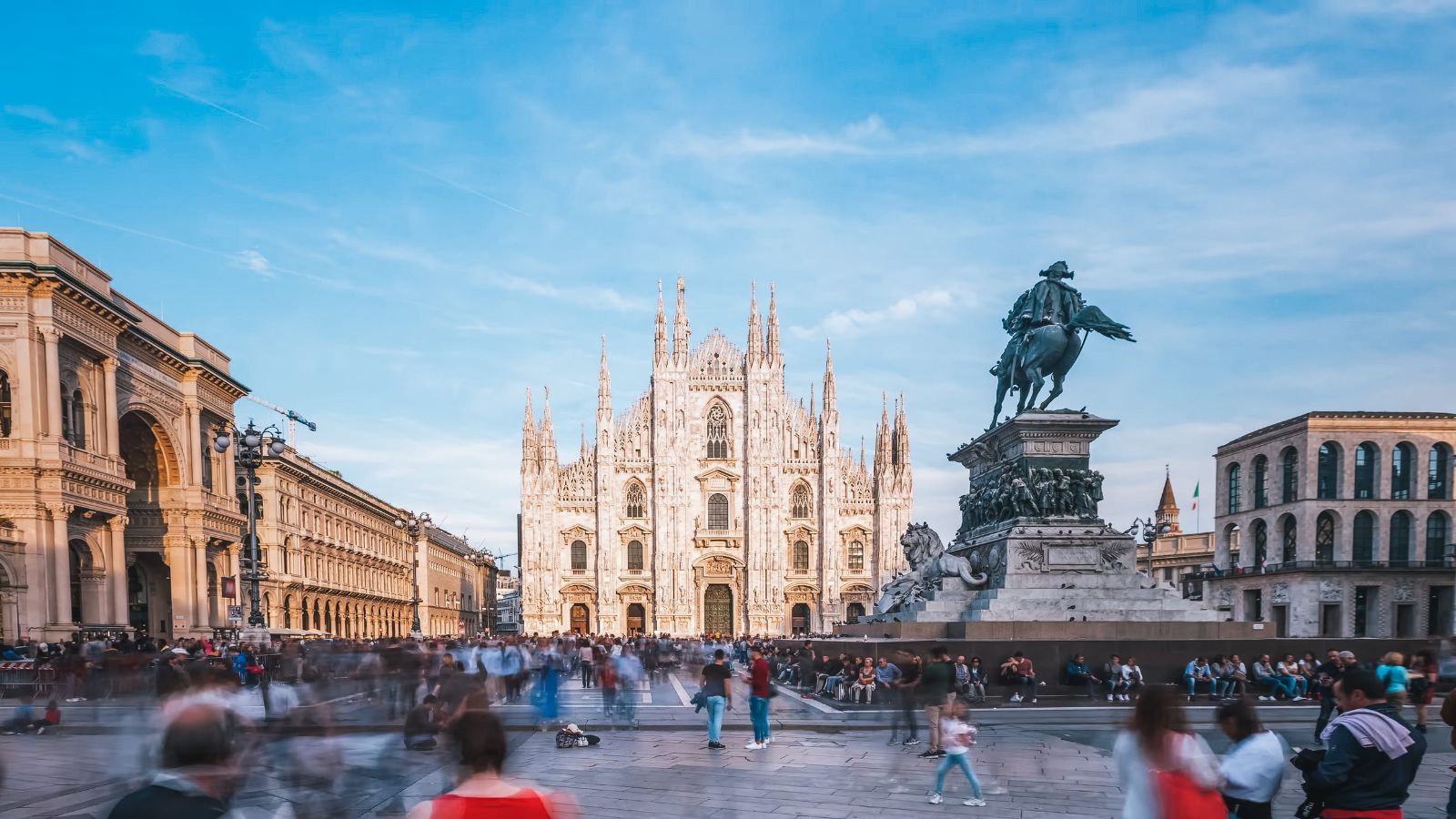 A photo of a grand European cathedral and historic buildings in a lively city square with travelers admiring the architecture.